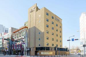 a tall brick building on a city street at Ilsan Hotel K in Goyang
