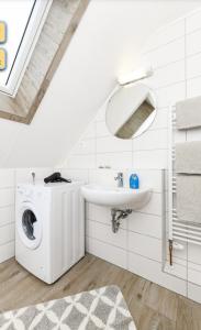 a bathroom with a washing machine and a sink at Haus Seemöwe Obergeschoss in Wittmund