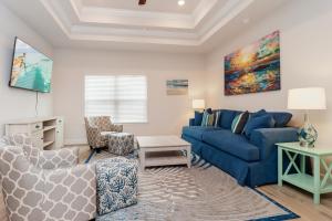 a living room with a blue couch and a table at WindMark Beach North by Pristine Properties Vacation Rentals in Saint Joe Beach