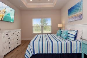a bedroom with a bed and a dresser and a window at WindMark Beach North by Pristine Properties Vacation Rentals in Saint Joe Beach +64 photos