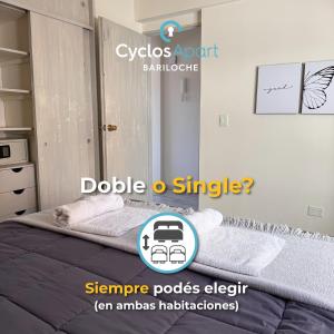 a bedroom with a bed with two towels on it at CyclosApart Bariloche in San Carlos de Bariloche