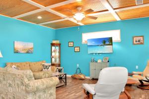 a living room with blue walls and a ceiling at Dolphin Daze by Pristine Properties Vacation Rentals in Saint Joe Beach