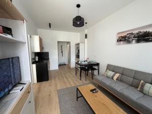 a living room with a couch and a table at Apartament between the bridges II in Zgorzelec
