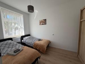 a bedroom with two beds and a window at Apartament between the bridges II in Zgorzelec