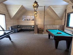 a room with a pool table and a couch at Pokoje Gościnne Przy Drodze in Białka Tatrzańska