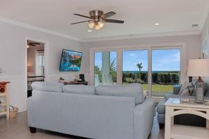 a living room with a couch and a ceiling fan at Deja Blue by Pristine Properties Vacation Rentals in Mexico Beach