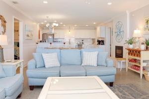 a living room with a blue couch and a kitchen at Deja Blue by Pristine Properties Vacation Rentals in Mexico Beach