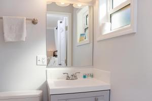 a white bathroom with a sink and a mirror at Deja Blue by Pristine Properties Vacation Rentals in Mexico Beach +54 photos