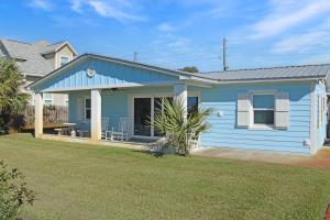 a blue house with a lawn in front of it at Deja Blue by Pristine Properties Vacation Rentals in Mexico Beach