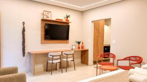 a living room with a table and chairs and a television at O Recanto Pousada in Serra Negra