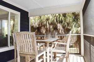 a porch with a table and chairs on a balcony at Latitude Adjustment by Pristine Properties Vacation Rentals in Indian Pass
