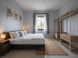 a bedroom with a large bed and a window at Nirvana Phangan Villas - Luxury & Serenity in Wok Tum +5 photos