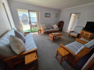 ein Wohnzimmer mit Sofas, Sesseln und einem Fernseher in der Unterkunft Bee Unique in Sedgefield