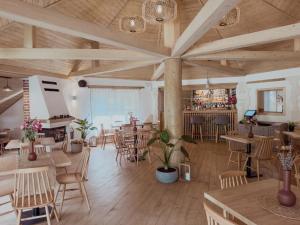 a restaurant with tables and chairs and a bar at Camping Ursulet Durau in Ceahlău