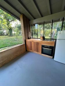 a kitchen with a stove and a refrigerator at Maisonnette chez Laurette in Saint-Martin-de-Seignanx