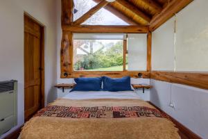 a bedroom with a bed in a room with a window at Blue Bird House in San Carlos de Bariloche