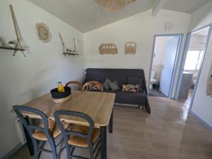 a living room with a table and a couch at Maisonnette chez Laurette in Saint-Martin-de-Seignanx +8 photos
