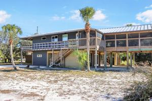 a house with palm trees in front of it at Quarters B by Pristine Properties in Mexico Beach