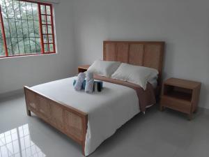 a bedroom with a bed with two teddy bears on it at Hotel Cafetero Valparaíso in La Vega +89 photos