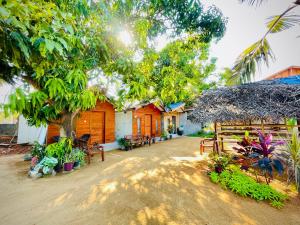 a group of houses with trees and plants at Mermaid Hostel in Trincomalee