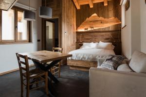 a bedroom with a bed and a table and a couch at Locanda Il Campo della Quercia in San Damiano Macra