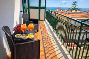 a table with drinks and snacks on a balcony at Blossom House in Isola delle Femmine