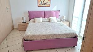 ein Schlafzimmer mit einem lila Bett und einem lila Kopfteil in der Unterkunft La trifula bianca apts. in Alba