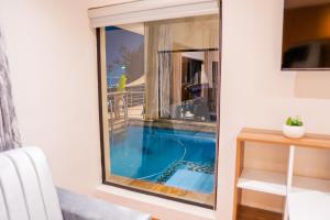 a view of a swimming pool through a glass window at AB&AB Guesthouse Bedfordview in Germiston