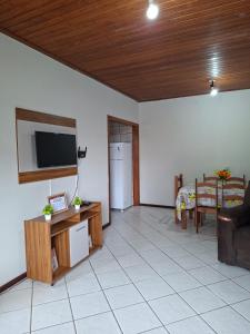 a living room with a television and a couch at Apartamento Day in Ilhéus