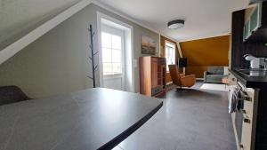 a kitchen with a table and a living room at Nordmannsland I in Sudermarsch +12 photos