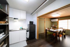 a kitchen with a table and a black refrigerator at とれるの【TORERUNO】 in Takayama