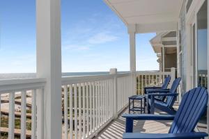 two blue chairs on a porch with the ocean at Las Brisas By Pristine Property Vacation Rentals in Saint Joe Beach