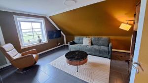 a living room with a couch and a chair at Nordmannsland I in Sudermarsch