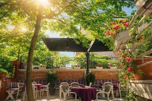 a patio with tables and chairs and flowers at Ufo Boutique Hotel in Tirana