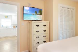 a bedroom with a television on top of a dresser at Pelican Roost E by Pristine Properties Vacation Rentals in Mexico Beach