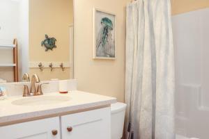 a bathroom with a sink and a shower curtain at Pelican Roost E by Pristine Properties Vacation Rentals in Mexico Beach +46 photos