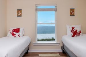 two beds in a room with a window at Pelican Roost E by Pristine Properties Vacation Rentals in Mexico Beach