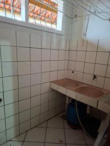 a tiled bathroom with a sink and a window at Apartamento Day in Ilhéus +19 photos