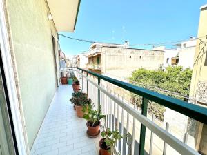 a balcony with potted plants on a building at Casa della Nonna - Art & Vintage Rooms in Noicattaro