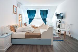 a bedroom with a bed with blue curtains at Pike Inn Bucătărie Autentică & Cazare cu Farmec in Dunavăţu de Sus