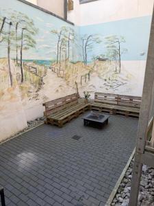a mural on the wall of a church with benches at Pension Zur Taube in Bautzen