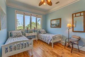 two beds in a room with blue walls at Island Idyl by Pristine Properties Vacation Rentals in Indian Pass