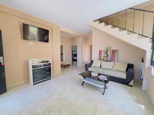 a living room with a couch and a staircase at Gulis Home in Shekhvetili