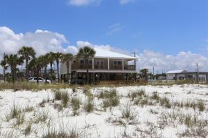 a house sitting on top of a sandy beach at One More Time Again by Pristine Properties Vacation Rentals in Mexico Beach