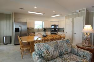 a kitchen and dining room with a table and a couch at One More Time Again by Pristine Properties Vacation Rentals in Mexico Beach