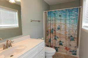 a bathroom with a toilet and a shower curtain at One More Time Again by Pristine Properties Vacation Rentals in Mexico Beach +23 photos