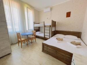 a bedroom with two bunk beds and a table and chairs at Gulis Home in Shekhvetili