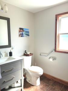 a bathroom with a toilet and a sink and a window at Guest Suite in Smiths Falls