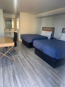 a hotel room with two beds and a desk at Clover motel in Lynwood
