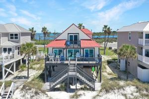 a house on the beach with palm trees at Sun Chaser by Pristine Properties Vacation Rentals in Cape San Blas